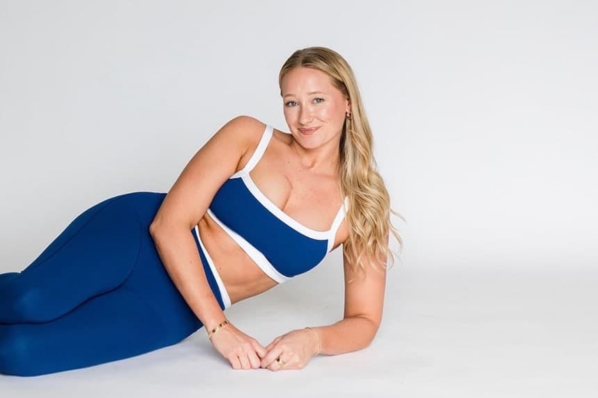 Dr. Julia resting on one side on a studio floor, propped on her forearms and looking towards the camera.